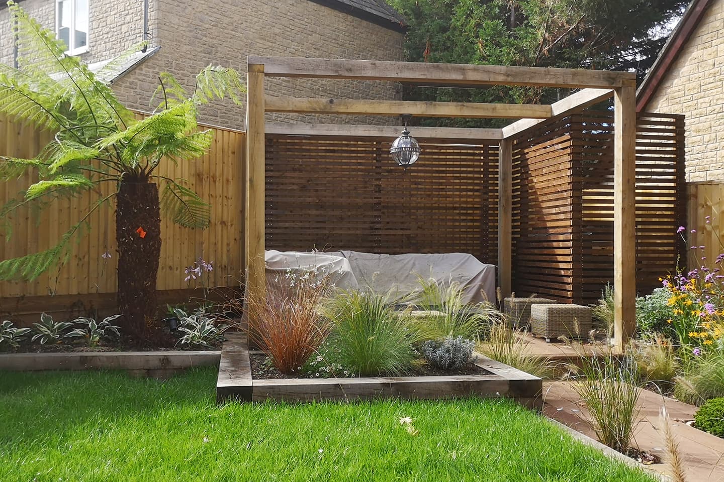 A simple open pergola housing a hidden infra-red heater and lantern light for use throughout the day, night and through all of the seasons.